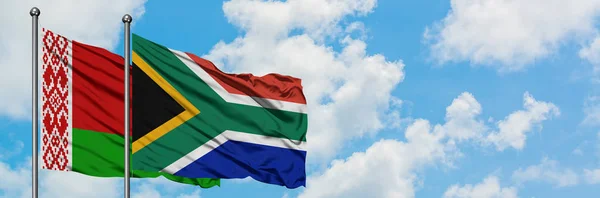 白俄罗斯和南非国旗在风中飘扬，白云蓝天相聚。外交概念、国际关系. — 图库照片