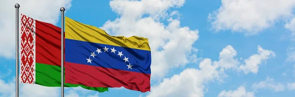 Belarus and Venezuela flag waving in the wind against white cloudy blue sky together. Diplomacy concept, international relations. — Stock Photo, Image