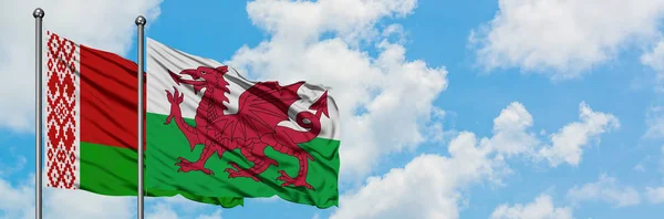 白俄罗斯和威尔士国旗在风中飘扬，白云蓝天相聚。外交概念、国际关系. — 图库照片