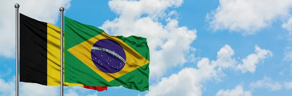 Bandera de Bélgica y Brasil ondeando en el viento contra el cielo azul nublado blanco juntos. Concepto diplomático, relaciones internacionales . — Foto de Stock