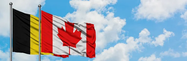 Bandera de Bélgica y Canadá ondeando en el viento contra el cielo azul nublado blanco juntos. Concepto diplomático, relaciones internacionales . — Foto de Stock