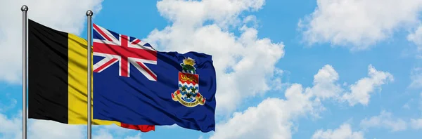 比利时和开曼群岛国旗在风中飘扬，与白云蓝天相一起。外交概念、国际关系. — 图库照片