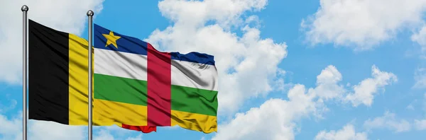 Bandera de Bélgica y República Centroafricana ondeando en el viento contra el cielo azul nublado blanco juntos. Concepto diplomático, relaciones internacionales . — Foto de Stock