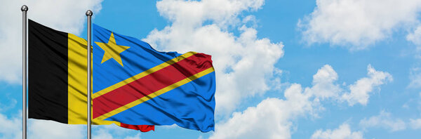 Belgium and Congo flag waving in the wind against white cloudy blue sky together. Diplomacy concept, international relations.