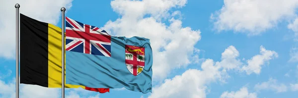 比利时和斐济国旗在风中飘扬，与白云蓝天相一起。外交概念、国际关系. — 图库照片