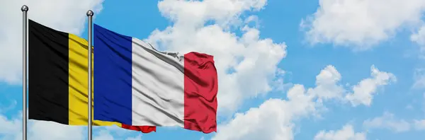 一緒に白い曇り青い空に対して風に手を振るベルギーとフランスの旗。外交概念、国際関係. — ストック写真