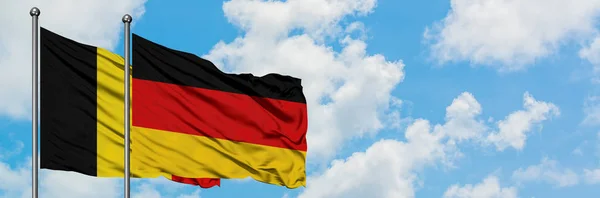 Belgio e Germania sventolano bandiera nel vento contro bianco cielo blu nuvoloso insieme. Concetto di diplomazia, relazioni internazionali . — Foto Stock