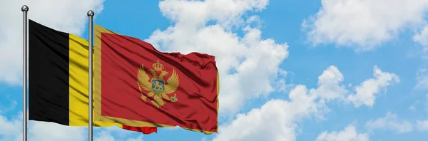 Belgien und Montenegro schwenken gemeinsam die Flagge im Wind vor dem wolkenverhangenen blauen Himmel. Diplomatie-Konzept, internationale Beziehungen. — Stockfoto