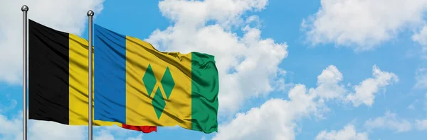 Belgium and Saint Vincent And The Grenadines flag waving in the wind against white cloudy blue sky together. Diplomacy concept, international relations. — Stock Photo, Image