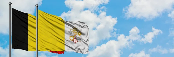 Belgium and Vatican City flag waving in the wind against white cloudy blue sky together. Diplomacy concept, international relations. — Stock Photo, Image