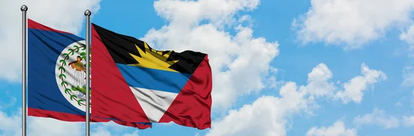 Belize ve Antigua ve Barbuda bayrağı birlikte beyaz bulutlu mavi gökyüzüne karşı rüzgarda sallayarak. Diplomasi kavramı, uluslararası ilişkiler. — Stok fotoğraf