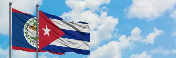 白い曇り青い空に向かって風に揺れ、ベリーズとキューバの旗が一緒に。外交概念、国際関係. — ストック写真