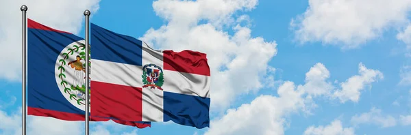 Belize e Repubblica Dominicana bandiera sventolando nel vento contro bianco cielo blu nuvoloso insieme. Concetto di diplomazia, relazioni internazionali . — Foto Stock