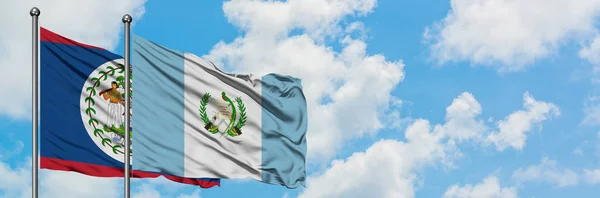 Беліз і Гватемала прапор розмахуючи в вітру проти білого хмарного синього неба разом. Концепція дипломатії, міжнародні відносини. — стокове фото