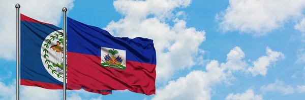 Belize ve Haiti bayrağı birlikte beyaz bulutlu mavi gökyüzüne karşı rüzgarda sallayarak. Diplomasi kavramı, uluslararası ilişkiler. — Stok fotoğraf