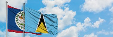 Belize ve Saint Lucia bayrağı birlikte beyaz bulutlu mavi gökyüzüne karşı rüzgarda sallayarak. Diplomasi kavramı, uluslararası ilişkiler.