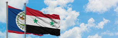 Belize ve Suriye bayrağı birlikte beyaz bulutlu mavi gökyüzüne karşı rüzgarda sallayarak. Diplomasi kavramı, uluslararası ilişkiler.