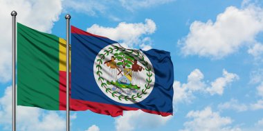 Benin ve Belize bayrağı birlikte beyaz bulutlu mavi gökyüzüne karşı rüzgarda sallayarak. Diplomasi kavramı, uluslararası ilişkiler.