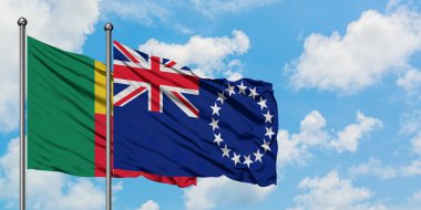 Benin ve Cook Adaları bayrak birlikte beyaz bulutlu mavi gökyüzüne karşı rüzgarda sallayarak. Diplomasi kavramı, uluslararası ilişkiler.