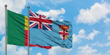 Benin ve Fiji bayrağı birlikte beyaz bulutlu mavi gökyüzüne karşı rüzgarda sallayarak. Diplomasi kavramı, uluslararası ilişkiler.