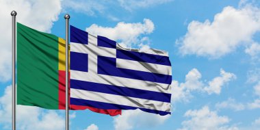 Benin ve Yunanistan bayrağı birlikte beyaz bulutlu mavi gökyüzüne karşı rüzgarda sallayarak. Diplomasi kavramı, uluslararası ilişkiler.