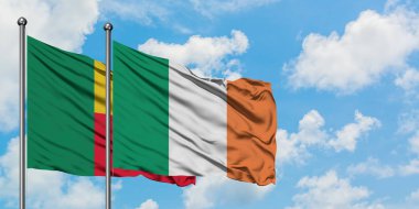 Benin ve İrlanda bayrağı birlikte beyaz bulutlu mavi gökyüzüne karşı rüzgarda sallayarak. Diplomasi kavramı, uluslararası ilişkiler.