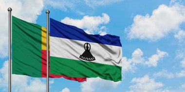 Benin ve Lesotho bayrağı birlikte beyaz bulutlu mavi gökyüzüne karşı rüzgarda sallayarak. Diplomasi kavramı, uluslararası ilişkiler.