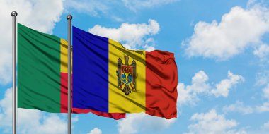 Benin ve Moldova bayrağı birlikte beyaz bulutlu mavi gökyüzüne karşı rüzgarda sallayarak. Diplomasi kavramı, uluslararası ilişkiler.