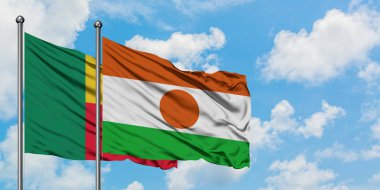 Benin ve Nijer bayrağı birlikte beyaz bulutlu mavi gökyüzüne karşı rüzgarda sallayarak. Diplomasi kavramı, uluslararası ilişkiler.