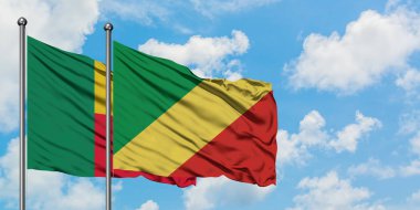 Benin ve Kongo Cumhuriyeti bayrağı birlikte beyaz bulutlu mavi gökyüzüne karşı rüzgarda sallayarak. Diplomasi kavramı, uluslararası ilişkiler.