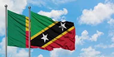 Benin ve Saint Kitts ve Nevis bayrak birlikte beyaz bulutlu mavi gökyüzüne karşı rüzgarda sallayarak. Diplomasi kavramı, uluslararası ilişkiler.