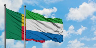 Benin ve Sierra Leone bayrağı birlikte beyaz bulutlu mavi gökyüzüne karşı rüzgarda sallayarak. Diplomasi kavramı, uluslararası ilişkiler.