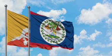 Bhutan ve Belize bayrağı birlikte beyaz bulutlu mavi gökyüzüne karşı rüzgarda sallayarak. Diplomasi kavramı, uluslararası ilişkiler.