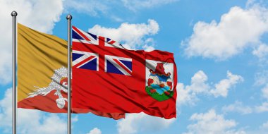 Bhutan ve Bermuda bayrağı birlikte beyaz bulutlu mavi gökyüzüne karşı rüzgarda sallayarak. Diplomasi kavramı, uluslararası ilişkiler.