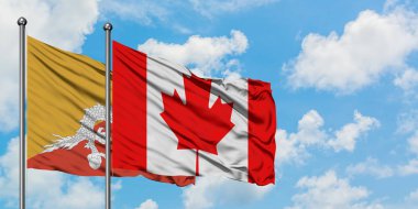 Bhutan ve Kanada bayrağı birlikte beyaz bulutlu mavi gökyüzüne karşı rüzgarda sallayarak. Diplomasi kavramı, uluslararası ilişkiler.