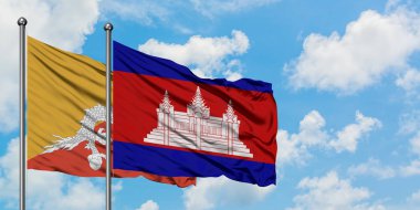 Bhutan ve Kamboçya bayrağı birlikte beyaz bulutlu mavi gökyüzüne karşı rüzgarda sallayarak. Diplomasi kavramı, uluslararası ilişkiler.