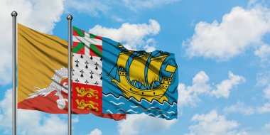 Butan ve Saint Pierre ve Miquelon bayrağı birlikte beyaz bulutlu mavi gökyüzüne karşı rüzgarda sallayarak. Diplomasi kavramı, uluslararası ilişkiler.