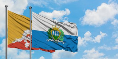 Bhutan ve San Marino bayrağı birlikte beyaz bulutlu mavi gökyüzüne karşı rüzgarda sallayarak. Diplomasi kavramı, uluslararası ilişkiler.