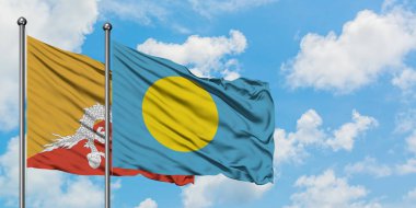 Bhutan ve Palau bayrağı birlikte beyaz bulutlu mavi gökyüzüne karşı rüzgarda sallayarak. Diplomasi kavramı, uluslararası ilişkiler.
