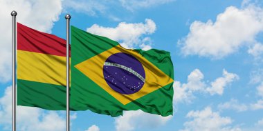 Bolivya ve Brezilya bayrağı birlikte beyaz bulutlu mavi gökyüzüne karşı rüzgarda sallayarak. Diplomasi kavramı, uluslararası ilişkiler.