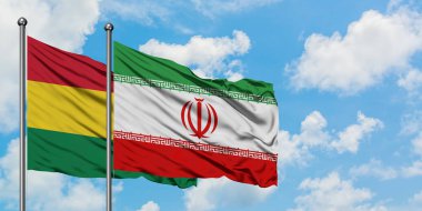 Bolivya ve İran bayrağı birlikte beyaz bulutlu mavi gökyüzüne karşı rüzgarda sallayarak. Diplomasi kavramı, uluslararası ilişkiler.