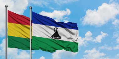 Bolivya ve Lesotho bayrağı birlikte beyaz bulutlu mavi gökyüzüne karşı rüzgarda sallayarak. Diplomasi kavramı, uluslararası ilişkiler.
