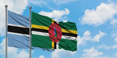 Botsvana ve Dominika bayrağı birlikte beyaz bulutlu mavi gökyüzüne karşı rüzgarda sallayarak. Diplomasi kavramı, uluslararası ilişkiler.