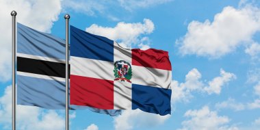 Botsvana ve Dominik Cumhuriyeti bayrağı birlikte beyaz bulutlu mavi gökyüzüne karşı rüzgarda sallayarak. Diplomasi kavramı, uluslararası ilişkiler.