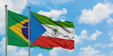 Brezilya ve Ekvator Ginesi bayrağı birlikte beyaz bulutlu mavi gökyüzüne karşı rüzgarda sallayarak. Diplomasi kavramı, uluslararası ilişkiler.