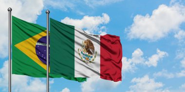 Brezilya ve Meksika bayrağı birlikte beyaz bulutlu mavi gökyüzüne karşı rüzgarda sallayarak. Diplomasi kavramı, uluslararası ilişkiler.