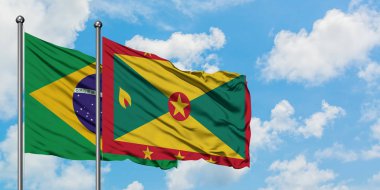 Brezilya ve Grenada bayrağı birlikte beyaz bulutlu mavi gökyüzüne karşı rüzgarda sallayarak. Diplomasi kavramı, uluslararası ilişkiler.