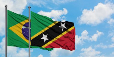 Brezilya ve Saint Kitts ve Nevis bayrağı birlikte beyaz bulutlu mavi gökyüzüne karşı rüzgarda sallayarak. Diplomasi kavramı, uluslararası ilişkiler.