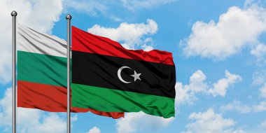 Bulgaristan ve Libya bayrağı birlikte beyaz bulutlu mavi gökyüzüne karşı rüzgarsal sallayarak. Diplomasi kavramı, uluslararası ilişkiler.
