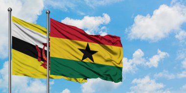 Brunei ve Gana bayrağı birlikte beyaz bulutlu mavi gökyüzüne karşı rüzgarda sallayarak. Diplomasi kavramı, uluslararası ilişkiler.